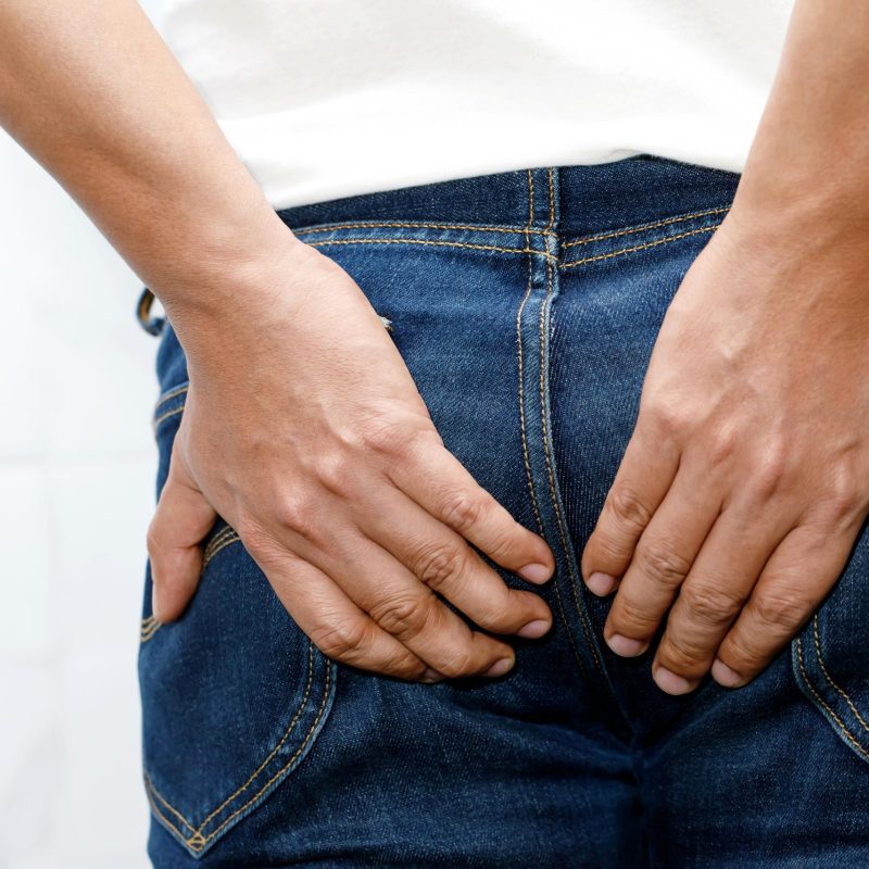 Man with hemorrhoids holding his butt in pain because having abdominal constipation and itching in the anus or anorectal abscess, Health care concept.